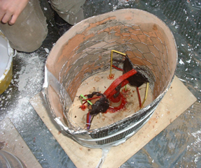 The plaster seals the joint between the tarpaper and the plywood.  Inside the flask is a layer of chicken-wire for reinforcement.