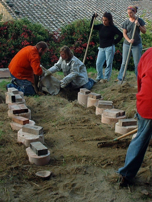 A good bit of sand is being shoveled and tossed around, and some of it could end up in a mold.